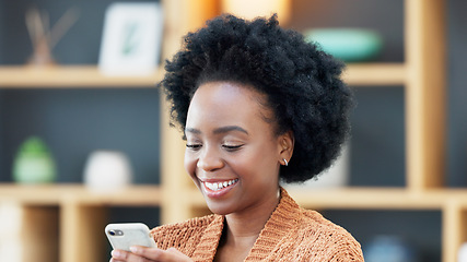Image showing Young woman smiling and laughing while texting on a phone at home. Cheerful female chatting to her friends on social media, browsing online and watching funny internet memes while relaxing in leisure