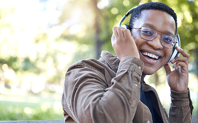 Image showing Headphones, park and portrait of black man listening to music for outdoor, mental health and relaxing break in nature. Young african student or happy person with audio technology in garden or campus