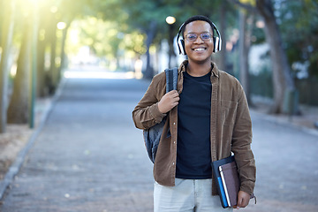 Image showing Music, education and portrait of a black man at a park for a walk, learning and studying in nature. Happy, university and African student with headphones for audio while ready to start college