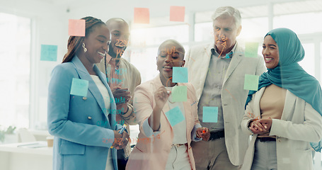 Image showing Business people, planning with glass board and collaboration with postit notes for brainstorming, communication and ideas. Vision, diversity and teamwork with Muslim woman writing, strategy and goals