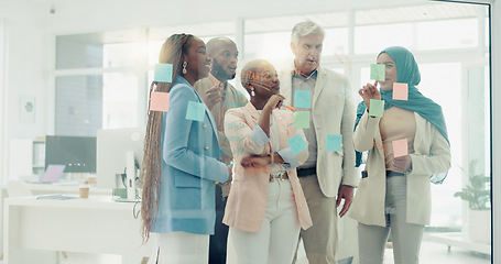 Image showing Meeting, planning and sticky notes on glass in the office with a diversity business team planning strategy. Teamwork, collaboration and coaching with a black woman leader teaching her staff at work