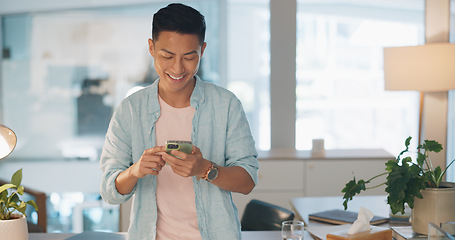 Image showing Cellphone, networking and Asian man on social media in the office typing on a lunch break. Technology, happy and male employee with a smile browsing internet or mobile app with cellphone in workplace