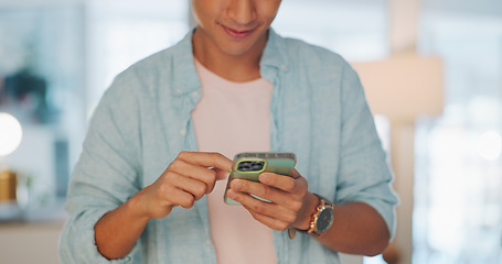 Image showing Cellphone, networking and Asian man on social media in the office typing on a lunch break. Technology, happy and male employee with a smile browsing internet or mobile app with cellphone in workplace