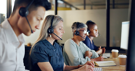 Image showing Senior call center consultant, woman and contact us, CRM and talking in customer service, computer at desk. Phone call, telemarketing and diversity, writing in notebook in coworking space and headset