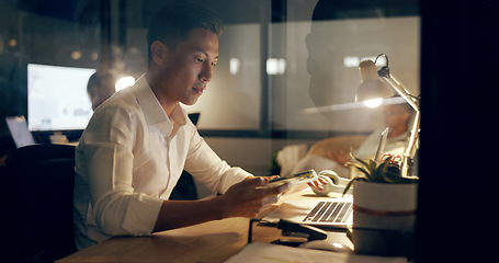 Image showing Asian businessman, laptop and phone at night working in marketing or advertising at office. Japanese employee man in web design at work on computer checking email, networking or online at workplace