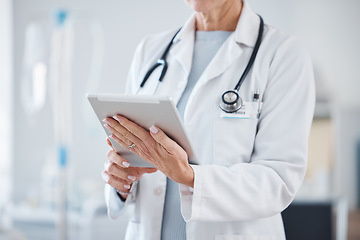 Image showing Healthcare, tablet and hands of senior doctor in hospital for online consulting, telehealth and wellness app. Clinic, medicine and woman on digital tech for internet, medical research or patient data