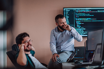 Image showing Programmers engrossed in deep collaboration, diligently working together to solve complex problems and develop innovative mobile applications with seamless functionality.