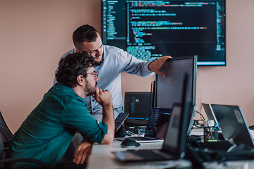 Image showing Programmers engrossed in deep collaboration, diligently working together to solve complex problems and develop innovative mobile applications with seamless functionality.