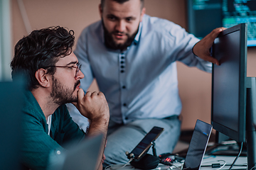 Image showing Programmers engrossed in deep collaboration, diligently working together to solve complex problems and develop innovative mobile applications with seamless functionality.