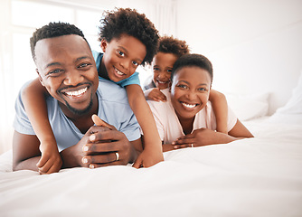 Image showing Happy, bonding and portrait of a black family on a bed for playing, quality time and comfort. Smile, love and African children with parents in the bedroom for happiness, relaxation and stress relief