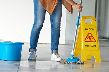 Image showing Cleaning, wet floor caution and woman mopping in building for maintenance, health or hygiene. Mop, janitor service and cleaner with warning notice, sign or safety information on slippery ground tiles