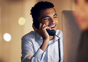 Image showing Telephone, night and businessman on a phone call in the office talking while working on a computer. Discussion, communication and professional male employee speaking on a landline in the workplace.