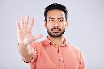 Image showing Stop, serious and portrait of an Asian man with a hand isolated on a grey studio background. Negative, no and Japanese guy with a gesture for rejection, deny and forbidden warning on a backdrop