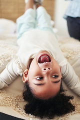 Image showing Children, fun and bed with a black girl playing upside down in a bedroom of her home looking excited. Kids, happy and playful with a young female child shouting or screaming while lying in a house