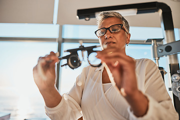 Image showing Optometry, test and woman with a lens for a checkup, vision measurement and fitting frame. Healthcare, expert and mature optometrist looking at glasses for a consultation, precsription and eyewear