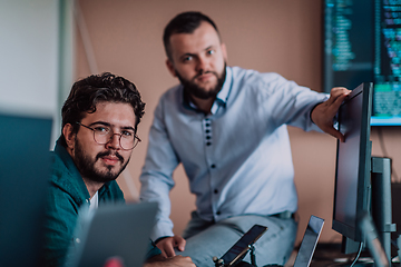 Image showing Programmers engrossed in deep collaboration, diligently working together to solve complex problems and develop innovative mobile applications with seamless functionality.