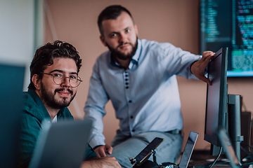 Image showing Programmers engrossed in deep collaboration, diligently working together to solve complex problems and develop innovative mobile applications with seamless functionality.