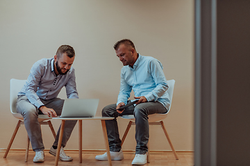 Image showing Programmers engrossed in deep collaboration, diligently working together to solve complex problems and develop innovative mobile applications with seamless functionality.