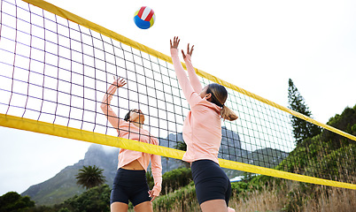 Image showing Volleyball, beach and spike with sports women playing a game outdoor for training or competition. Team, sport and ball with female friends on the sand by the coast to play a competitive match