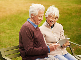 Image showing Internet, park and senior couple with a tablet for communication, video call and scrolling. Nature, hug and elderly man and woman with technology for social media and reading an email in Argentina