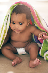 Image showing Baby, infant and child development for little or small kid in a towel being cute, curious and adorable in a home or house. Children, innocent and babies or newborn playing and sitting on a table