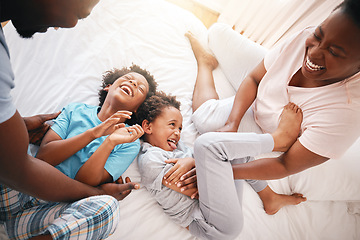 Image showing Tickle, laugh and relax with black family in bedroom for bonding, playful and affectionate. Funny, happiness and crazy with parents playing with children at home for wake up, morning and silly