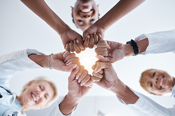 Image showing Doctor, group and fist hands in circle for teamwork portrait, happiness or support in hospital for healthcare goal. Doctors, clinic team and huddle for motivation, solidarity and diversity with women