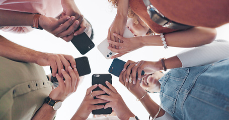 Image showing Hands, phone and communication with friends standing in a huddle or circle from below for networking. Social media, mobile and 5g with a man and woman friend group connected to the internet together