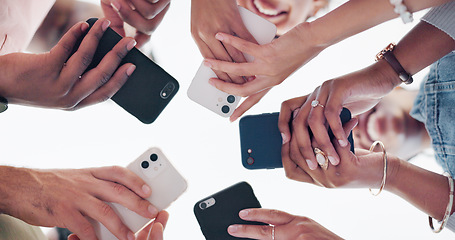 Image showing Hands, phone and communication with friends standing in a huddle or circle from below for networking. Social media, mobile and 5g with a man and woman friend group connected to the internet together