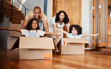 Image showing Children in boxes while moving into a new home with their parents playing in a silly, goofy and fun mood. Happy, smile and family being playful together in their modern house, apartment or property.