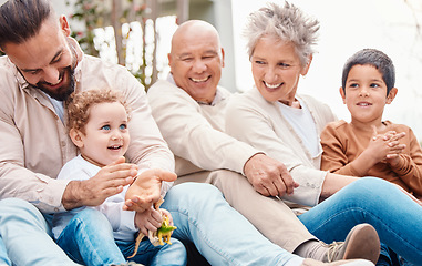 Image showing Bonding, happy and family laughing during a visit for love, care and happiness. Playing, interracial and grandparents, children and father in a garden for quality time, playful and cheerful together