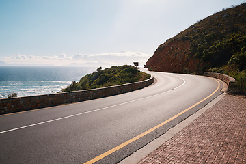 Image showing Mountain, road and ocean view with no people for travel, destination or sightseeing in Cape Town. Nature, beauty on empty street for road trip, vacation or holiday on South Africa blue sky background