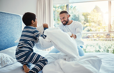 Image showing Love, father and son in bedroom, pillow fight and happiness on vacation, quality time and break. Family, dad and boy on bed, playful and smile for bonding, loving and carefree with joy and cheerful