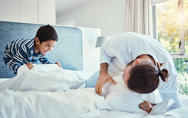 Image showing Happiness, fun and father in pillow fight with his child on the bed in the bedroom of family house. Love, smile and happy dad being playful with his boy kid while bonding and playing at their home.