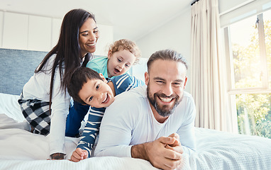 Image showing Family, portrait and laughing on bed in home, having fun and bonding together. Comic, love and care of happy father, mother and kids or boys playing, smile and enjoying quality time in house bedroom.