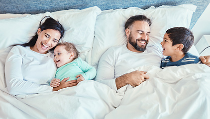 Image showing Waking up, bed and family relax, happy and bond while resting, talking and laughing from above at home. Bedroom, fun and kids with parents in the morning, playful and caring while lying and embracing