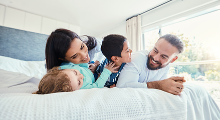 Image showing Happy, love and family being playful on the bed together in the bedroom of their modern house. Happiness, excited and children having fun, playing and bonding with their parents in a room at home.