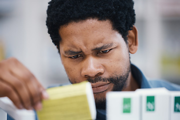 Image showing Black man, shopping or reading in pharmacy for medicine, choice or pills in retail healthcare for wellness. African customer, box or sale for health, deal or thinking for benefits of medical product