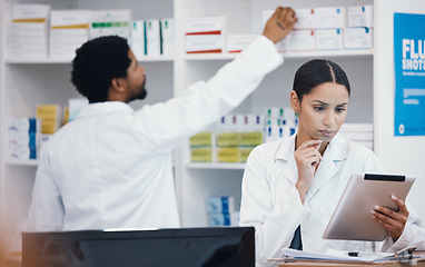 Image showing Thinking pharmacist, woman and tablet in medicine check, stock take or medical research in drugs store. Serious, ideas and pharmacy worker on technology pills, checklist or ecommerce healthcare order