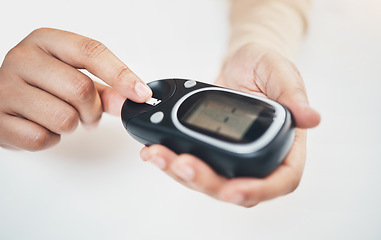 Image showing Diabetes, blood test and medical with finger of woman for insulin level, monitoring and glucose check. Medicine, healthcare and digital with hands of patient and glucometer machine for sugar balance