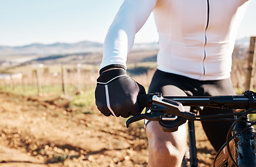 Image showing Man, hands and bicycle in countryside, nature and training in sunshine for triathlon, sports and cardio competition. Cyclist gloves, bike and outdoor fitness for cycling marathon, exercise and race