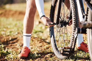 Image showing Man, hands and mountain bike wheel repair in park for training, triathlon sports gear and workout exercise. Cyclist, bicycle and check tire chain for travel safety, cycling maintenance and fixing hub