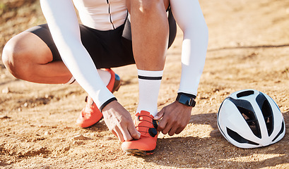 Image showing Closeup, tie shoelace and man with fitness, outdoor and helmet for safety, wellness and hobby for exercise. Zoom, shoes and male athlete with protection, sand and in nature for training and workout