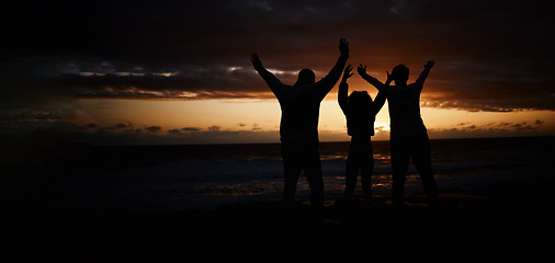 Image showing Freedom, sunset and silhouette of a family at the beach while on a summer vacation or weekend trip. Adventure, carefree and shadow of people by the ocean together while on a seaside travel holiday.