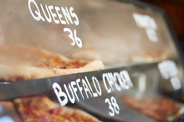 Image showing Shop display, pizza and fast food price, service and take away restaurant with closeup, storefront and window. Dinner, nutrition at cafe or bakery, lunch or dinner with to go meal option in New York