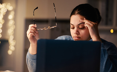 Image showing Black woman, headache and home office laptop of a student with stress and burnout. Night, online university project and anxiety of a young female with glasses and blurred background in the dark