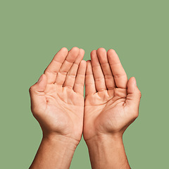 Image showing Hands, welfare and poverty with a man in studio on a green background begging for help or support. Hope, community and palm cupping with a person closeup asking for humanitarian aid or kindness