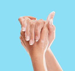 Image showing Washing, soap and hands of woman in studio for hygiene, sanitary and disinfection. Cleaning, foam and dermatology with person and bubbles for wellness, natural and health isolated on blue background