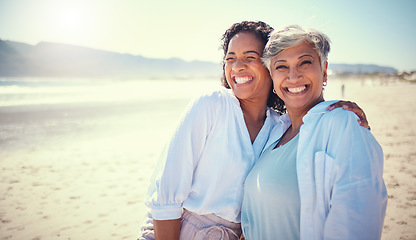 Image showing Mother with her adult daughter at the beach while on a vacation, weekend trip or summer getaway. Happy, smile and woman embracing her senior mom by the ocean while on a tropical holiday or adventure.