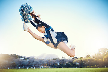 Image showing Sports, performance and woman cheerleader jumping while performing a routine on the field at an arena. Fitness, exercise and female doing a trick or skill while training or practicing for the show.